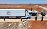 Une photo aérienne montre un convoi du Croissant-Rouge syrien transportant de l'aide humanitaire fournie par le gouvernement intérimaire syrien, franchissant un poste de contrôle des forces de sécurité générales syriennes près de la ville méridionale de Busra al-Sham, le 20 juillet 2025, alors qu'il se dirige vers la ville à majorité druze de Soueïda après des affrontements sectaires meurtriers. (Crédit : Omar Haj Kadour/AFP)