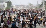 Des Gazaouis marchant dans la rue al-Rashid, dans l'ouest de Jabaliya, le 23 juillet 2025, après avoir reçu de l'aide humanitaire dans un centre de distribution situé dans le nord de la bande de Gaza. (Crédit : Eyad Baba/AFP)
