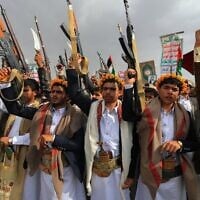Des Yéménites brandissant leurs fusils et scandant des slogans lors d'un rassemblement anti-Israël et anti-américain, dans la capitale contrôlée par les Houthis, Sanaa, le 25 juillet 2025. (Crédit : Mohammed Huwais/AFP)
