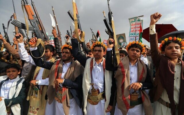 Des Yéménites brandissant leurs fusils et scandant des slogans lors d'un rassemblement anti-Israël et anti-américain, dans la capitale contrôlée par les Houthis, Sanaa, le 25 juillet 2025. (Crédit : Mohammed Huwais/AFP)