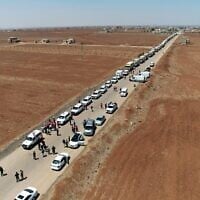Des camions du Croissant-Rouge syrien transportant de l'aide humanitaire arrivant à Busra al-Sham, dans la province de Deraa, dans le sud de la Syrie, avant de traverser la zone tampon pour entrer dans la province de Soueïda, le 28 juillet 2025. (Crédit : SANA/AFP)
