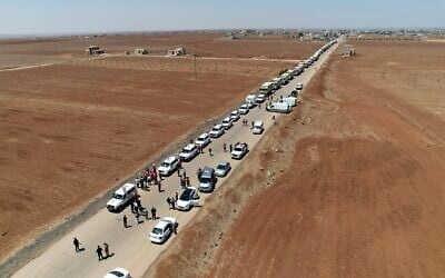 Des camions du Croissant-Rouge syrien transportant de l'aide humanitaire arrivant à Busra al-Sham, dans la province de Deraa, dans le sud de la Syrie, avant de traverser la zone tampon pour entrer dans la province de Soueïda, le 28 juillet 2025. (Crédit : SANA/AFP)