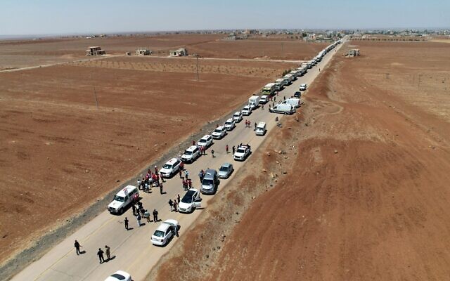 Des camions du Croissant-Rouge syrien transportant de l'aide humanitaire arrivant à Busra al-Sham, dans la province de Deraa, dans le sud de la Syrie, avant de traverser la zone tampon pour entrer dans la province de Soueïda, le 28 juillet 2025. (Crédit : SANA/AFP)