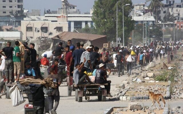 Des Gazaouis déplacés dans le camp de réfugiés de Nuseirat transportant des colis alimentaires et d'autres articles qu'ils ont réussi à obtenir auprès d'un point de distribution de l'aide de la GHF, dans le centre de la bande de Gaza, le 30 juillet 2025. (Crédit : Eyad Baba/AFP) Des Gazaouis déplacés dans le camp de réfugiés de Nuseirat transportant des colis alimentaires et d'autres articles qu'ils ont réussi à obtenir auprès d'un point de distribution de l'aide de la GHF, dans le centre de la bande de Gaza, le 30 juillet 2025. (Crédit : Eyad Baba/AFP)