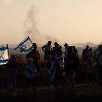 Des manifestants de droite israéliens se rassemblent sur une colline surplombant la bande de Gaza, près de la barrière frontalière, le 30 juillet 2025, lors d'un rassemblement marquant le 20ᵉ anniversaire du retrait israélien de Gaza (Crédit : Menahem KAHANA / AFP)
