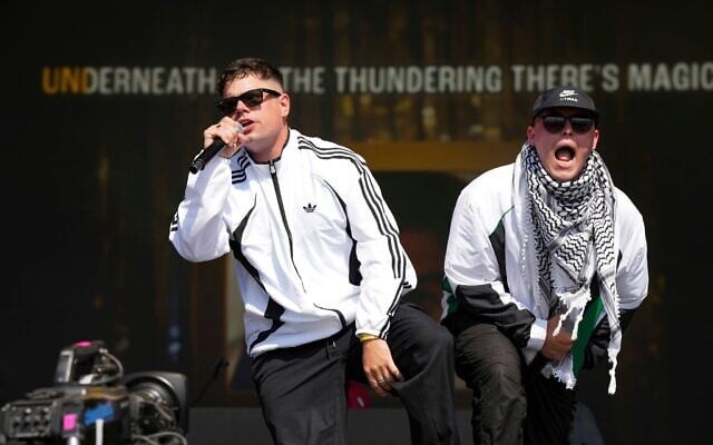 Naoise Ó Cairealláin (à gauche) et Liam Óg, du trio de hip-hop Kneecap, sur scène lors du festival de Glastonbury, le 28 juin 2025. (Crédit : Scott A Garfitt/Invision/AP)