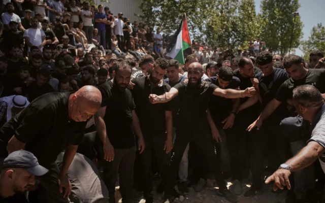 Des personnes aux funérailles des Américains d'origine palestinienne Saif Musallet, 20 ans, et Mohammed al-Shalabi lors de leurs funérailles dans le village d'Al-Mazraa ash-Sharqiya en Cisjordanie, le dimanche 13 juillet 2025. (Crédit : Leo Correa/AP)