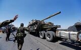Un char du régime syrien est transporté sur un camion alors que les forces se retirent de la ville de Sweida, sur l'autoroute de Daraa, dans le sud de la Syrie, le mardi 15 juillet 2025. (Crédit : Omar Sanadiki/AP)