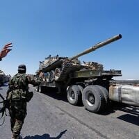 Un char du régime syrien est transporté sur un camion alors que les forces se retirent de la ville de Sweida, sur l'autoroute de Daraa, dans le sud de la Syrie, le mardi 15 juillet 2025. (Crédit : Omar Sanadiki/AP)
