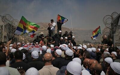 Des Druzes de Syrie et d'Israël manifestant à la frontière israélo-syrienne, le 16 juillet 2025. (Crédit : Leo Correa/AP)