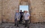 L'Ambassadeur des États-Unis en Israël Mike Huckabee, à gauche, est escorté par le Père Jack-Noble Abed, prêtre de l'Église grecque-catholique melchite, lors d'une visite du site archéologique de l'Église Saint-Georges, site d'une récente attaque de résidents d'implantations israéliens, lors de sa visite dans la ville cisjordanienne de Taybeh, à l'est de Ramallah, samedi 19 juillet 2025. (Crédit : AP Photo/Nasser Nasser)