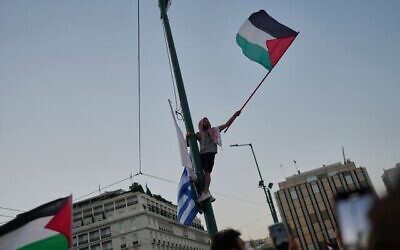 Un manifestant brandissant un drapeau "palestinien" lors d'une manifestation contre la guerre dans la bande de Gaza devant le Parlement grec, dans le centre-ville d'Athènes, le 24 juillet 2025. (Crédit : Petros Giannakouris/AP)