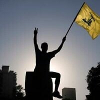 Un partisan du Hezbollah brandit un drapeau du Hezbollah devant le siège de la Commission économique et sociale des Nations Unies pour l'Asie occidentale (CESAO) à Beyrouth, au Liban, le 26 juillet 2025. (Crédit : AP Photo/Bilal Hussein)