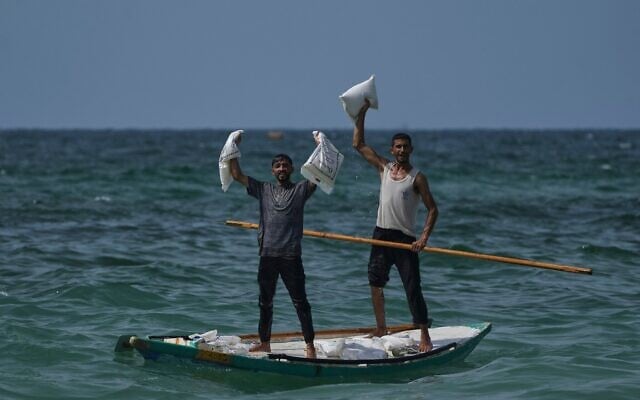 Des Palestiniens collectent de l'aide qui a atterri dans la mer Méditerranée après avoir été larguée au-dessus du centre de Gaza, sur le rivage de Zawaida, dans la bande de Gaza, le 29 juillet 2025. (Crédit : AP Photo/Abdel Kareem Hana) Des Palestiniens collectent de l'aide qui a atterri dans la mer Méditerranée après avoir été larguée au-dessus du centre de Gaza, sur le rivage de Zawaida, dans la bande de Gaza, le 29 juillet 2025. (Crédit : AP Photo/Abdel Kareem Hana)
