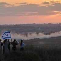 Des militants de droite israéliens surveillent le nord de la bande de Gaza lors d'un rassemblement appelant au rétablissement des implantations juives dans la bande de Gaza, près de la frontière sud d'Israël, le mercredi 30 juillet 2025. (Crédit : AP/Ohad Zwigenberg)