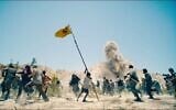 Un enfant du pays fictif de Jahranpur brandit un drapeau improvisé de Superman lors d'une attaque des soldats du pays fictif de Boravia, dans "Superman", un film réalisé en 2025 par James Gunn. (Crédit : DC Studios/Warner Bros. via JTA)