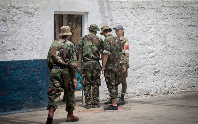 Un officier de la police militaire s'entretenant avec des soldats israéliens emprisonnés à Arba, la plus grande prison militaire d'Israël, située dans la base militaire de Tzrifin, le 26 avril 2018. (Crédit : Miriam Alster/FLASH90)