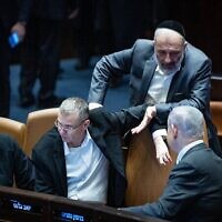 Aryeh Deri, chef du Shas (debout), s’entretient avec le Premier ministre Benjamin Netanyahu, assis près des ministres Yariv Levin et Itamar Ben Gvir, à la Knesset (assis de droite à gauche), à Jérusalem, le 6 décembre 2023. (Crédit : Yonatan Sindel/Flash90)