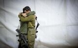 Des soldats de l'armée israélienne s'étreignant lors des funérailles du réserviste Zvika Lavi, au cimetière militaire du mont Herzl, à Jérusalem, le 12 décembre 2023. (Crédit : Yonatan Sindel/Flash90)