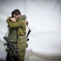 Des soldats de l'armée israélienne s'étreignant lors des funérailles du réserviste Zvika Lavi, au cimetière militaire du mont Herzl, à Jérusalem, le 12 décembre 2023. (Crédit : Yonatan Sindel/Flash90)