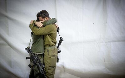 Des soldats de l'armée israélienne s'étreignant lors des funérailles du réserviste Zvika Lavi, au cimetière militaire du mont Herzl, à Jérusalem, le 12 décembre 2023. (Crédit : Yonatan Sindel/Flash90)