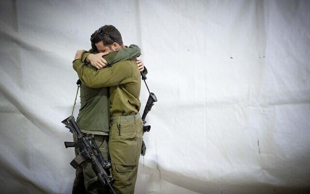 Des soldats de l'armée israélienne s'étreignant lors des funérailles du réserviste Zvika Lavi, au cimetière militaire du mont Herzl, à Jérusalem, le 12 décembre 2023. (Crédit : Yonatan Sindel/Flash90) Des soldats de l'armée israélienne s'étreignant lors des funérailles du réserviste Zvika Lavi, au cimetière militaire du mont Herzl, à Jérusalem, le 12 décembre 2023. (Crédit : Yonatan Sindel/Flash90)