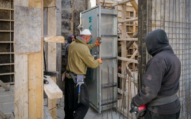 Des ouvriers druzes construisant un abri antiatomique (mamad), à Katzrin, sur le plateau du Golan, le 26 janvier 2025. (Crédit : Michael Giladi/FLASH90)