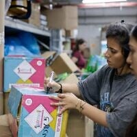 Des bénévoles préparant des kits destinés à être distribués à de jeunes familles à Jérusalem, pendant la guerre entre la République islamique et Israël, le 15 juin 2025. (Crédit : Rachel Alroey/Flash90)