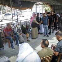 Des visiteurs réconfortent la famille en deuil d'Awdah Hathaleen dans le village palestinien d'Umm al-Kheir, dans le sud de la Cisjordanie, le 29 juillet 2025. (Crédit : Wisam Hashlamoun/Flash90)