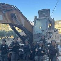 Des gardes-frontières posant avec une excavatrice soupçonnée d'avoir été volée à l'armée, sur une photo diffusée le 17 juillet 2025. (Crédit : Porte-parole de la police)