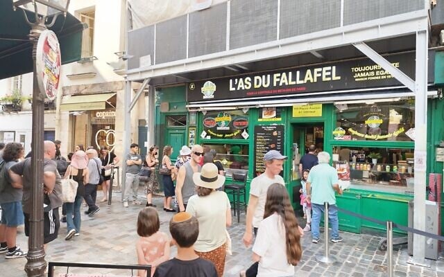 Des clients devant L'As du Fallafel, dans le quartier historiquement juif du Marais, à Paris, le 11 juillet 2025. (Crédit : Zev Stub/Times of Israel).