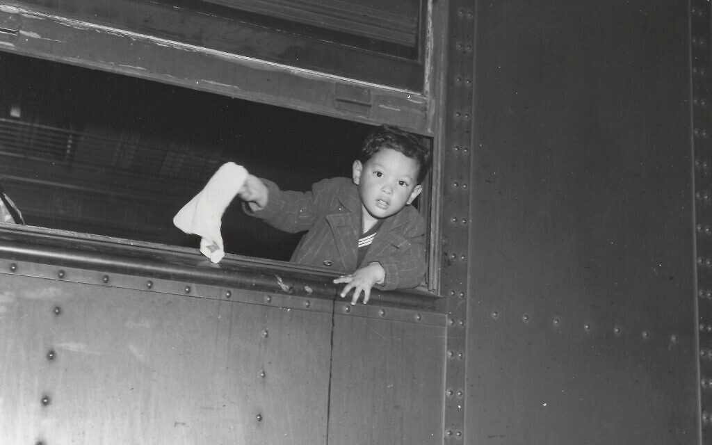 Tommy Yoneda dans le train pour Manzanar, faisant un signe d'adieu. (Autorisation : Karl G. Yoneda Papers, UCLA Library Special Collections)