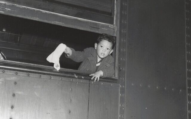 Tommy Yoneda dans le train pour Manzanar, faisant un signe d'adieu. (Autorisation : Karl G. Yoneda Papers, UCLA Library Special Collections)