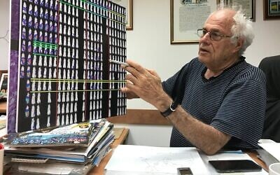 Le professeur Zelig Eshhar de l'Institut Weizmann tient un tableau qui illustre le fonctionnement du traitement contre le cancer chez les souris, le 29 août 2017. (Crédit : Shoshanna Solomon/Times of Israel)