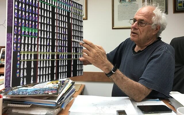 Le professeur Zelig Eshhar de l'Institut Weizmann tient un tableau qui illustre le fonctionnement du traitement contre le cancer chez les souris, le 29 août 2017. (Crédit : Shoshanna Solomon/Times of Israel)