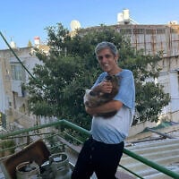 Le poète iranien Payam Feili, qui a obtenu l'asile politique par Israël, au balcon de son logement à Haïfa, le 1er juillet 2025. (Crédit : Rossella Tercatin/Times of Israel)