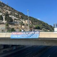 Une banderole sur laquelle on peut lire « Pas de discrimination entre le sang et le sang. Recrutement pour tous » accrochée sur un pont, en Israël, le 16 juillet 2025. (Crédit : Autorisation)