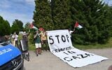 Des manifestants brandissent des drapeaux palestiniens et affirment qu'un génocide se déroule à Gaza devant le camp d'extermination d'Auschwitz, en Pologne, le 6 mai 2024. (Crédit : Canaan Lidor / Times of Israel)