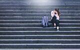 Illustration : Une élève bouleversée assise dans la cour d'une école. (Crédit : iStock par Getty Images)