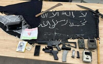 Un drapeau de l'Etat islamique, des armes et des talkies-walkies trouvés par des policiers lors de l'arrestation d'un homme soupçonné d'incitation au terrorisme à Tuba-Zangariyye le 29 juin, sur une photo publiée par la Police israélienne le 22 juillet 2025. (Police israélienne)