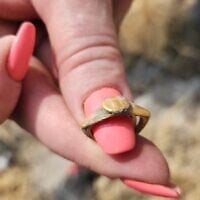 Une bague en or de l'époque romaine trouvée lors de fouilles archéologiques dans le parc national de Sussita (Hippos) au mois de juillet 2025. (Crédit : Michael Eisenberg)