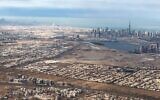 Une vue aérienne prise le 1er janvier 2022 depuis un avion de ligne montre une vue générale de l'émirat du Golfe de Dubaï avec, en arrière-plan, la capitale des Émirats arabes unis, Abou Dhabi. (Crédit : Marina Passos / AFP)