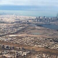 Une vue aérienne prise le 1er janvier 2022 depuis un avion de ligne montre une vue générale de l'émirat du Golfe de Dubaï avec, en arrière-plan, la capitale des Émirats arabes unis, Abu Dhabi. (Crédit : Marina Passos / AFP)