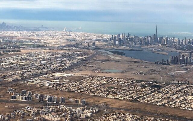 Une vue aérienne prise le 1er janvier 2022 depuis un avion de ligne montre une vue générale de l'émirat du Golfe de Dubaï avec, en arrière-plan, la capitale des Émirats arabes unis, Abu Dhabi. (Crédit : Marina Passos / AFP)
