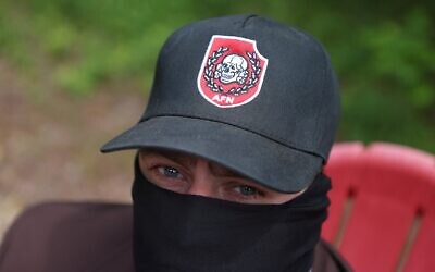 Henry Stout, membre du groupe néonazi Aryan Freedom Network, dissimulant son identité, lors d'une séance photo, dans le sud de l'Oklahoma, le 5 mai 2025. (Crédit : Jim Urquhart/REUTERS)