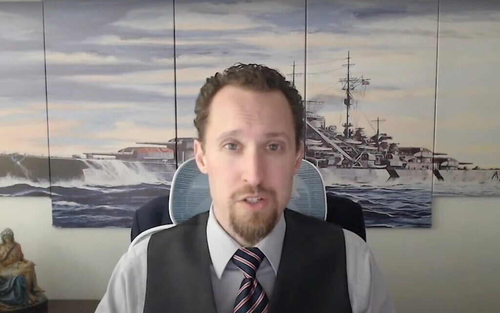 L'économiste E.J. Antoni, nommé en août 2025 par le président Trump à la tête du Bureau of Labor Statistics, interviewé devant une œuvre représentant le navire de guerre nazi Bismarck, le 9 décembre 2024. (Crédit : Capture d'écran/ YouTube ; via JTA)