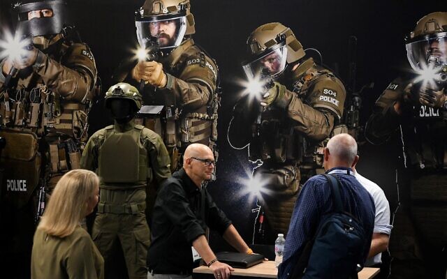 Des visiteurs observant des fusils lors du salon Defence and Sécurité Equipment International (DSEI), au centre ExCeL, à Londres, le 12 septembre 2023. (Crédit : Daniel Leal/AFP)