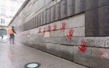 Un employé municipal nettoie le « Mur des Justes » au mémorial de la Shoah, à Paris, vandalisé, le 14 mai 2024. (Crédit : Antonin Utz/AFP)