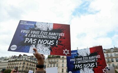 Photo d'illustration : Des manifestants brandissent une pancarte sur laquelle on peut lire « Vous êtes habitués à l'antisémitisme ? Nous, non », lors d'un rassemblement pour condamner le viol collectif antisémite présumé d'une fillette de 12 ans, devant la mairie de Paris, le 19 juin 2024. (Crédit : Alain Jocard/AFP) Photo d'illustration : Des manifestants brandissent une pancarte sur laquelle on peut lire « Vous êtes habitués à l'antisémitisme ? Nous, non », lors d'un rassemblement pour condamner le viol collectif antisémite présumé d'une fillette de 12 ans, devant la mairie de Paris, le 19 juin 2024. (Crédit : Alain Jocard/AFP)