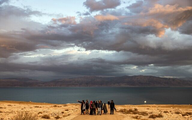 Des randonneurs lors d'une excursion le long du rivage de la mer Morte, près du kibboutz Ein Gedi, dans l'est d'Israël, le 30 décembre 2024. (Crédit : Menahem Kahana/AFP)